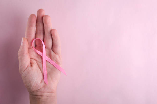 vue supérieure de la main de la femme et du ruban rose là-dessus. concept de soins de santé et cancer du sein - surgical pin photos et images de collection