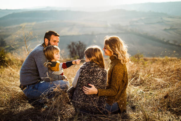 istock Young happy family talking while relaxing in autumn day. 1174967874