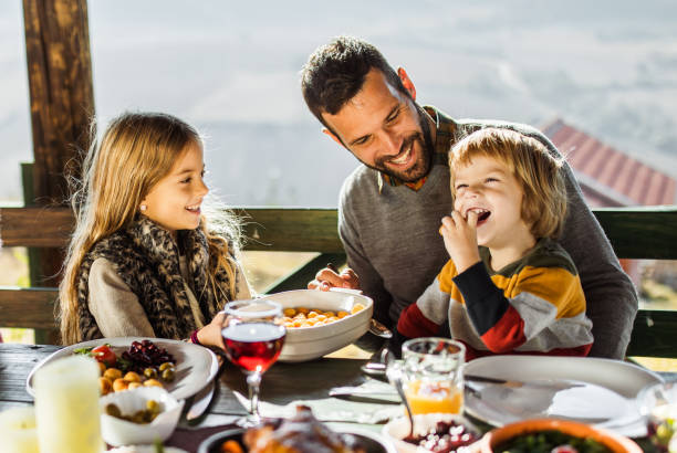 istock Happy single father enjoying with kids during lunch on a balcony. 1174969992
