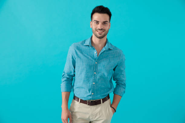 istock man in blue shirt standing with one hand in pocket 1174972993