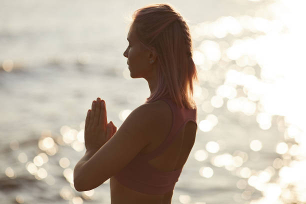 istock Woman meditating on the beach 1174974667