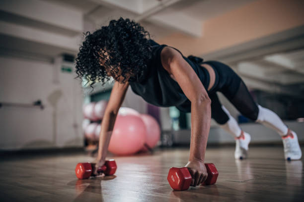 istock Beautiful lady doing push-ups in gym 1174976930