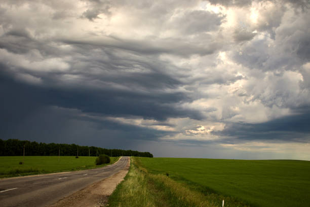 istock country road along the field under heavy clouds 1174977293