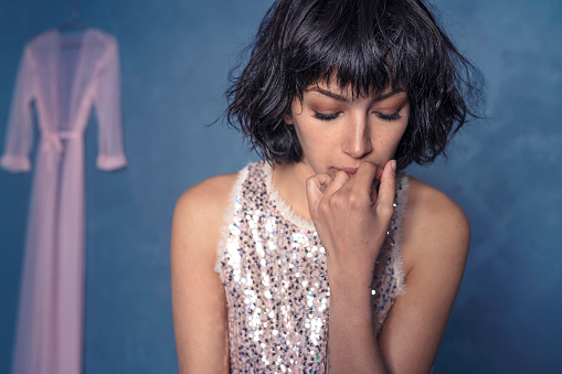 Pensive sad young woman with sequins dress