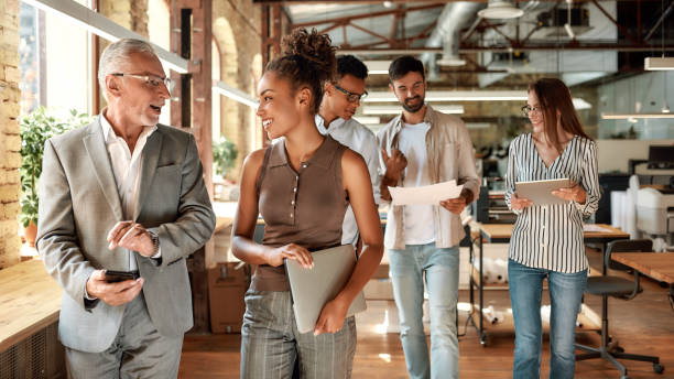istock Before meeting. Two business experts discussing something while walking with colleagues through the office corridor 1174978810