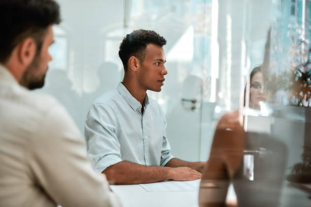 istock At the meeting. Young african man discussing something with his colleagues while sitting at the office table 1174979174