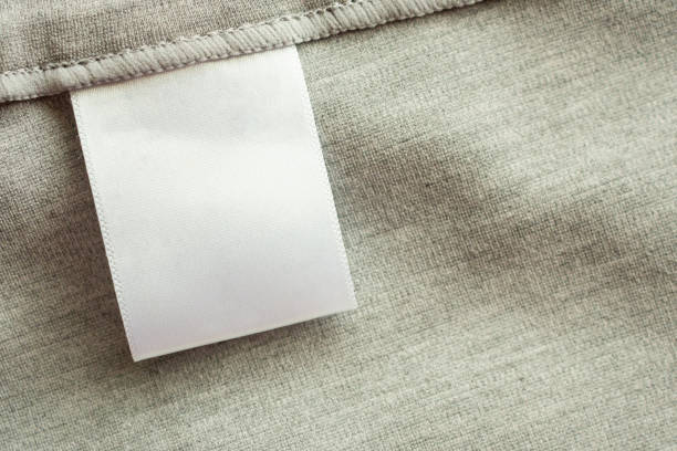 белый пустой прачечной одежды этикетки на серый фон текстуры ткани - label textile shirt stitch стоковые фото и изображения