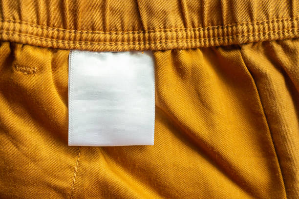 white blank clothing tag label on brown cotton shorts fabric texture background - scale industry copy space special imagens e fotografias de stock