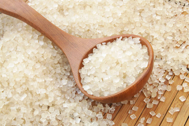 istock Spoon and sugar on brown bamboo background 1174984697