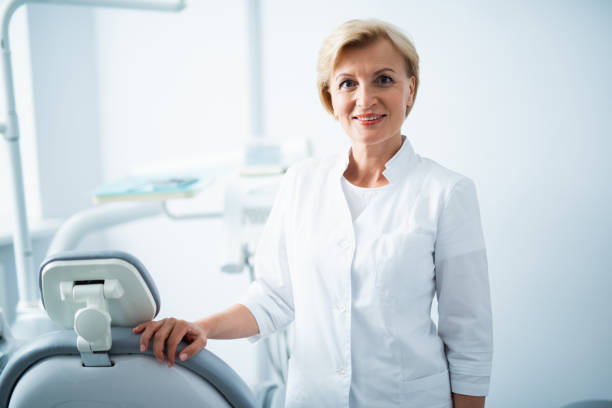 istock Female dentist is posing in dental office 1174986073
