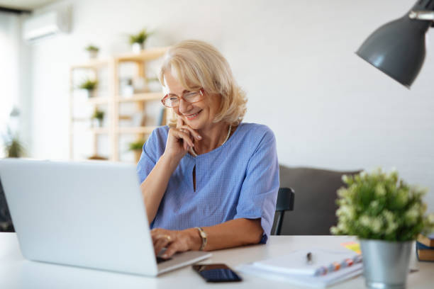 istock Senior woman using laptop at home 1174986816