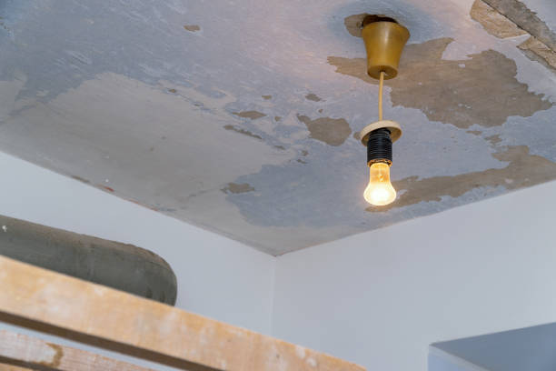 istock Light bulb hanging on the background of shabby ceiling 1174987031
