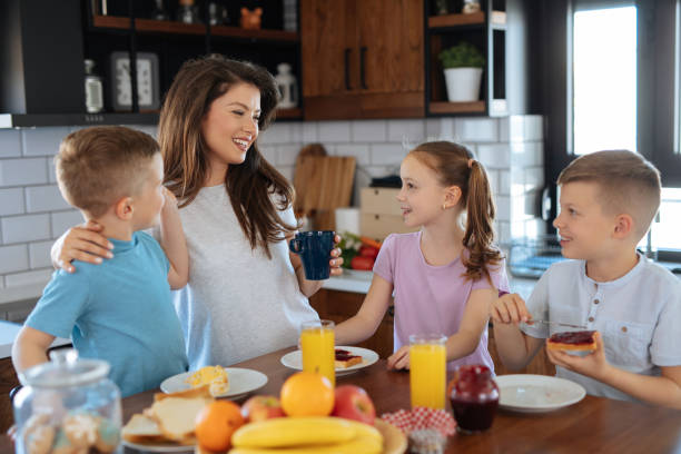 istock Mother and three kids in the kitchen eating breakfast 1174987683