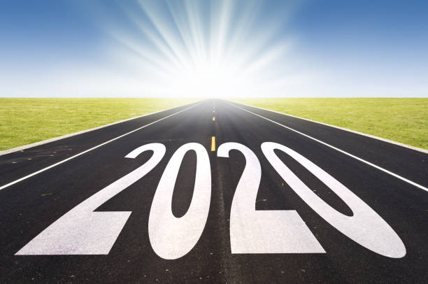 istock 2020 road perspective with rising sun, new year card 1174990027