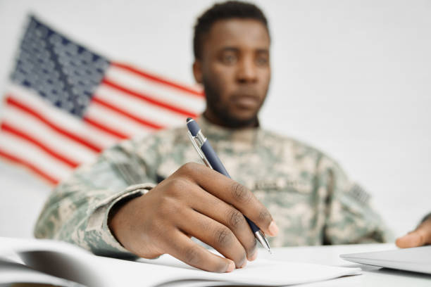 istock Male soldier hand holding pen and writing document. 1174990812