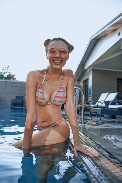 istock Pretty young girl posing for camera in swimming pool 1174992734