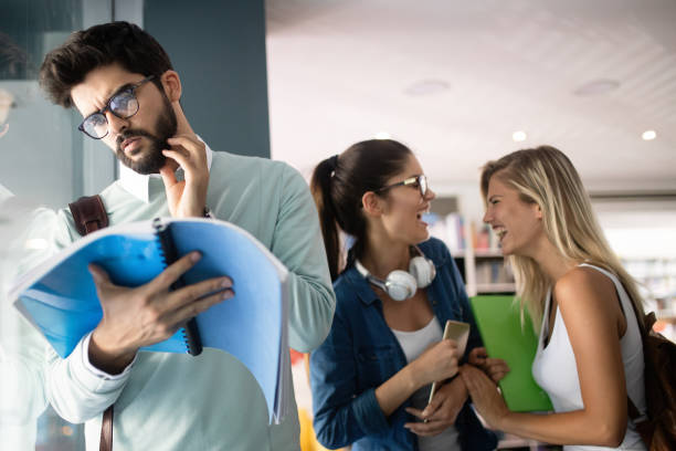 istock Happy young university students friends studying with books at university 1174992795
