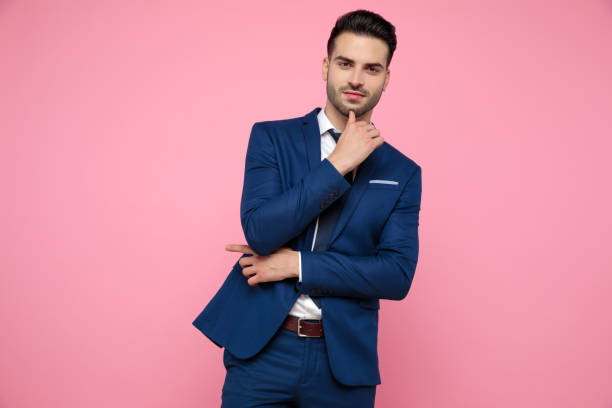 istock attractive young man pointing finger to side on pink background 1174994588