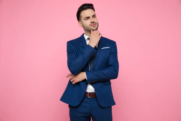 istock handsome young man thinking and presenting to side on pink background 1174994613