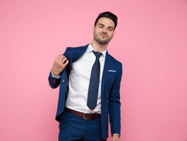 istock handsome young man holding coat on pink background 1174994759