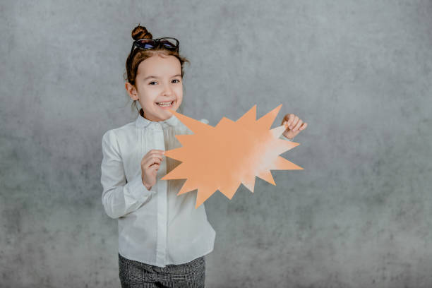 istock Young girl holding speech bubble on blue background 1174996541