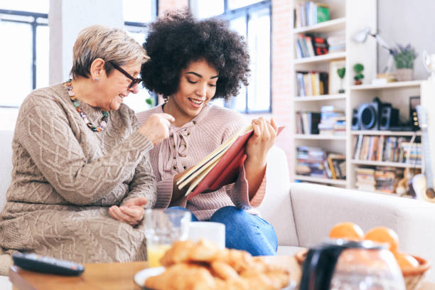 istock Mother and daughter sitting on sofa at home 1174996886