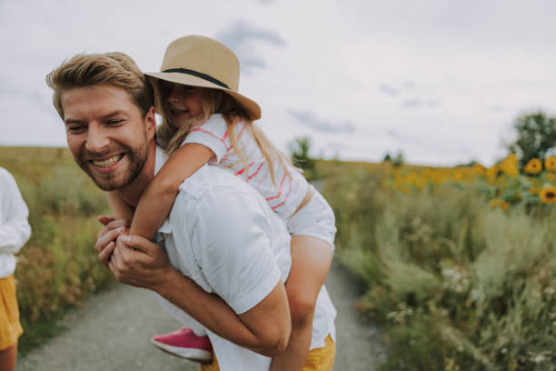 istock Small joyful daughter spending time with her dad near field 1174998127