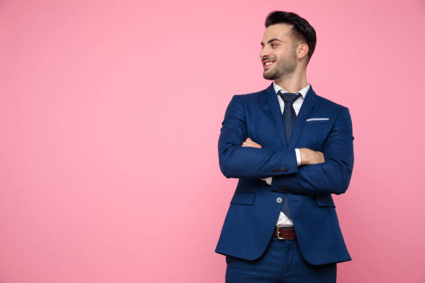 istock attractive young man standing and looking to side on pink background 1174999463