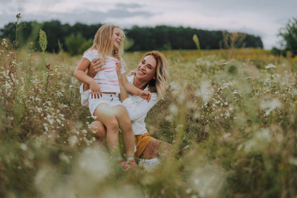 istock Happy lady hugging her small daughter in field 1174999499
