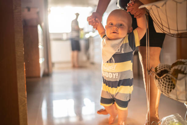 istock Babysitter helping baby boy learn to walk at home 1175000637