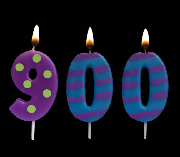 istock Burning birthday candle isolated on black, number 900 1175002681