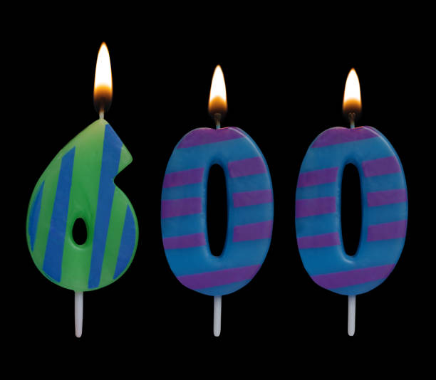 istock Burning birthday candle isolated on black, number 600 1175002814