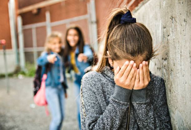 A sad girl intimidation moment on the elementary Age Bullying in Schoolyard A sad girl intimidation moment Elementary Age Bullying in Schoolyard school violence stock pictures, royalty-free photos & images
