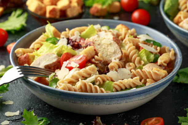 pasta de ensalada césar con pollo, tomate, queso parmesano y verduras - noodles pasta chicken breast color image fotografías e imágenes de stock