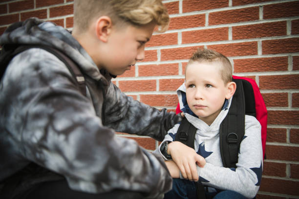 istock boy problem at school, sitting and consoling child each other 1175004463