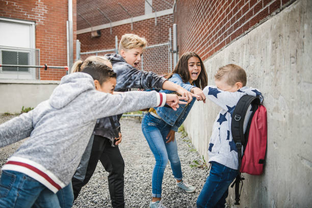triste momento di intimidazione elementary age bullismo a schoolyard - bullying sneering rejection child foto e immagini stock