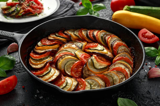 istock Ratatouille Vegetable Stew with zucchini, eggplants, tomatoes, garlic, onion and basil. on cast iron pan. Traditional French food. 1175005080