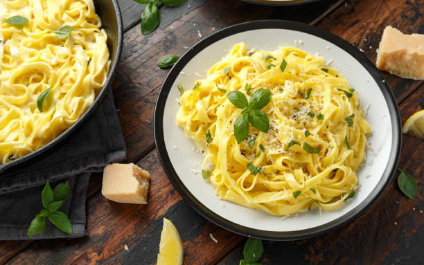 istock Pasta al Limone, Lemon with basil and parmesan cheese on wooden table 1175005285