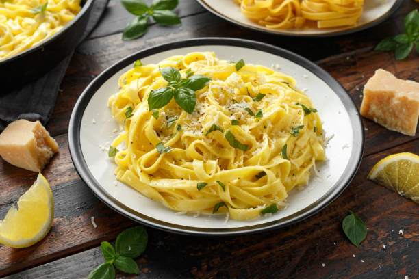 istock Pasta al Limone, Lemon with basil and parmesan cheese on wooden table 1175005332