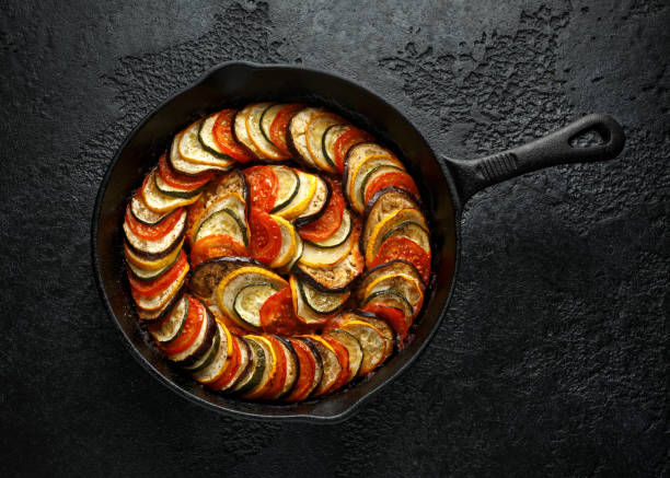 istock Ratatouille Vegetable Stew with zucchini, eggplants, tomatoes, garlic, onion and basil. on cast iron pan. Traditional French food. 1175005383