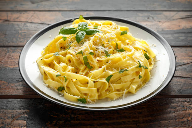 istock Pasta al Limone, Lemon with basil and parmesan cheese on wooden table 1175005468