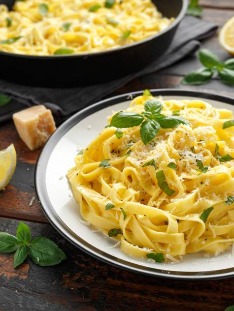 istock Pasta al Limone, Lemon with basil and parmesan cheese on wooden table 1175005522