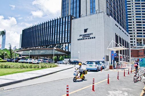 Taxicabs and cars at the drop off-pick up spot of JW Marriott Hotel in Futian business district, Shenzhen - China. JW Marriott (named fater named after the founder) is a luxury hotel chain of Marriott International