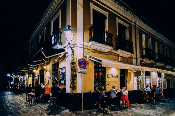 turistas que se relajan en terrazas de bares de tapas tradicionales durante el centro histórico de sevilla, andalucía, españa - seville sevilla santa cruz city fotografías e imágenes de stock