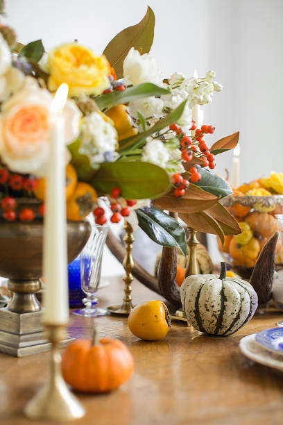 istock Luxurious elegant wedding decor in autumn style. Wooden vintage table setting with ceramic plates and silver cutlery. Fresh flowers in a vase, orange pumpkins, deer horns and candles. Romantic dinner. 1175008885