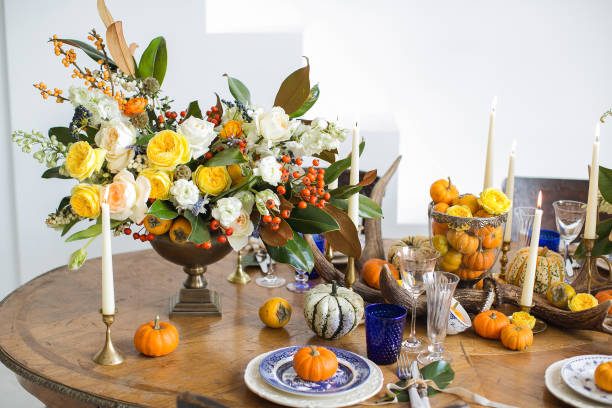 istock Luxurious elegant wedding decor in autumn style. Wooden vintage table setting with ceramic plates and silver cutlery. Fresh flowers in a vase, orange pumpkins, deer horns and candles. Romantic dinner. 1175011171