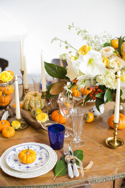 istock Luxurious elegant wedding decor in autumn style. Wooden vintage table setting with ceramic plates and silver cutlery. Fresh flowers in a vase, orange pumpkins, deer horns and candles. Romantic dinner. 1175011445