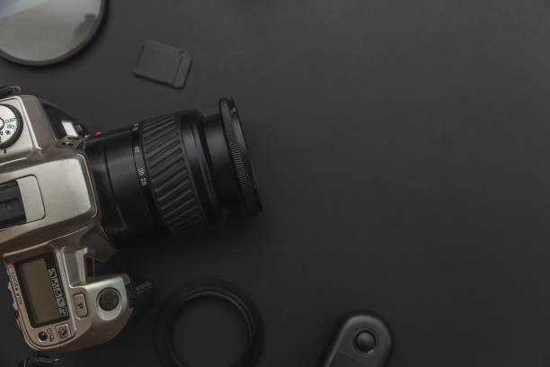 istock Photographer workplace with dslr camera system, camera cleaning kit, lens and camera accessory on dark black table background 1175014917