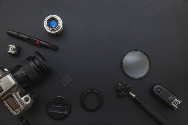 istock Photographer workplace with dslr camera system, camera cleaning kit, lens and camera accessory on dark black table background 1175014933