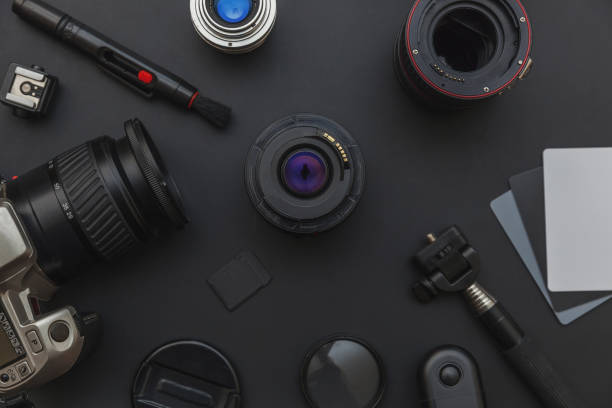 istock Photographer workplace with dslr camera system, camera cleaning kit, lens and camera accessory on dark black table background 1175014966